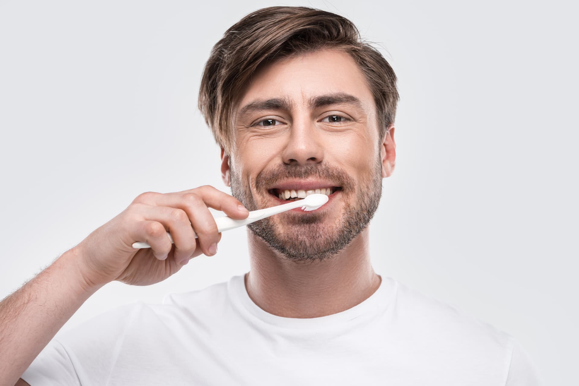 man brushing teeth and dental implants